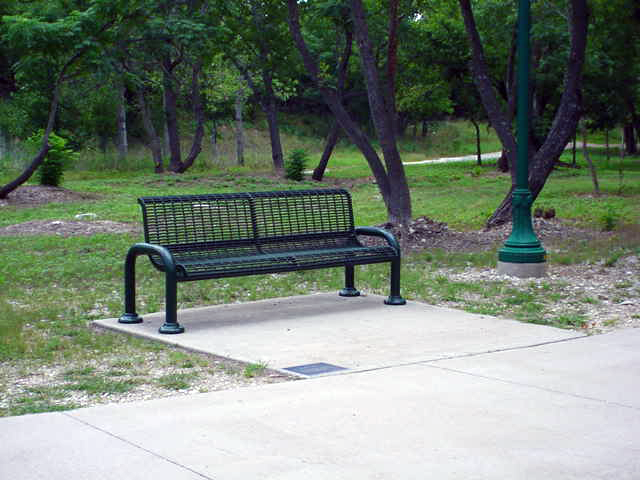 Green bench with plaque in San Gabriel Park in Georgetown, TX