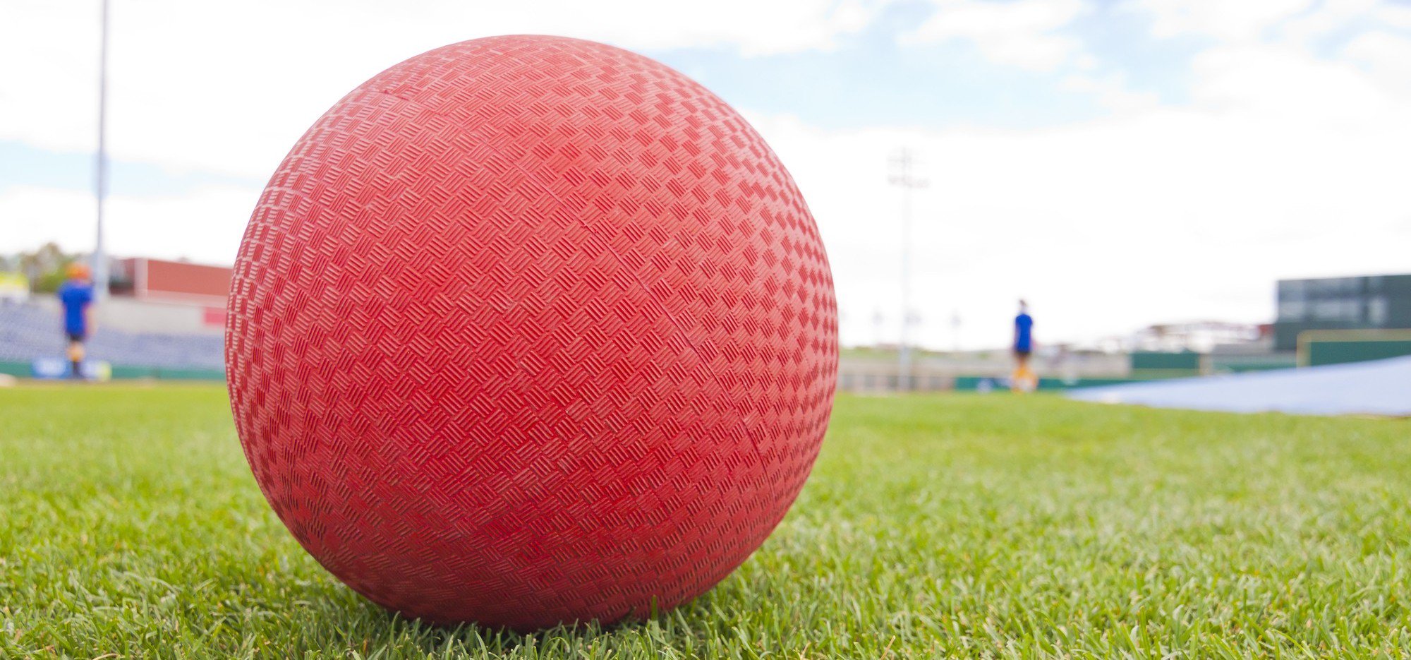 Close up of a red kickball on a grass field