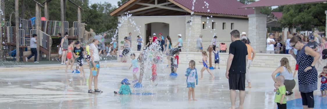 People playing in the splash pad at Garey Park