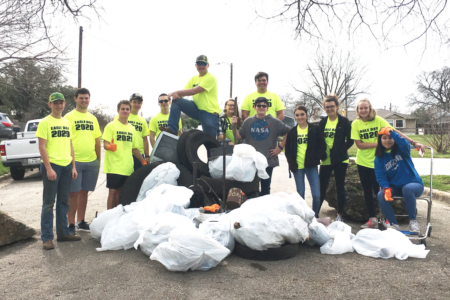 Group of volunteers posing with trash that they collected in the park
