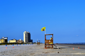 Lifeguard station on a beach flying a yellow flag