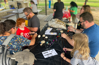 Families painting rocks at May the Fourth Be With You pop up event in San Gabriel Park