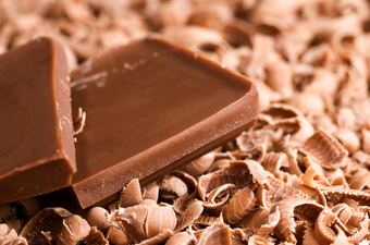close up of milk chocolate pieces with shavings underneath