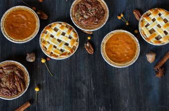 overhead of three mini pies - apple pie pumpkin pie and pecan pie