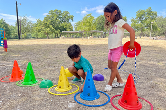 two children playing with an obstacle course in a park
